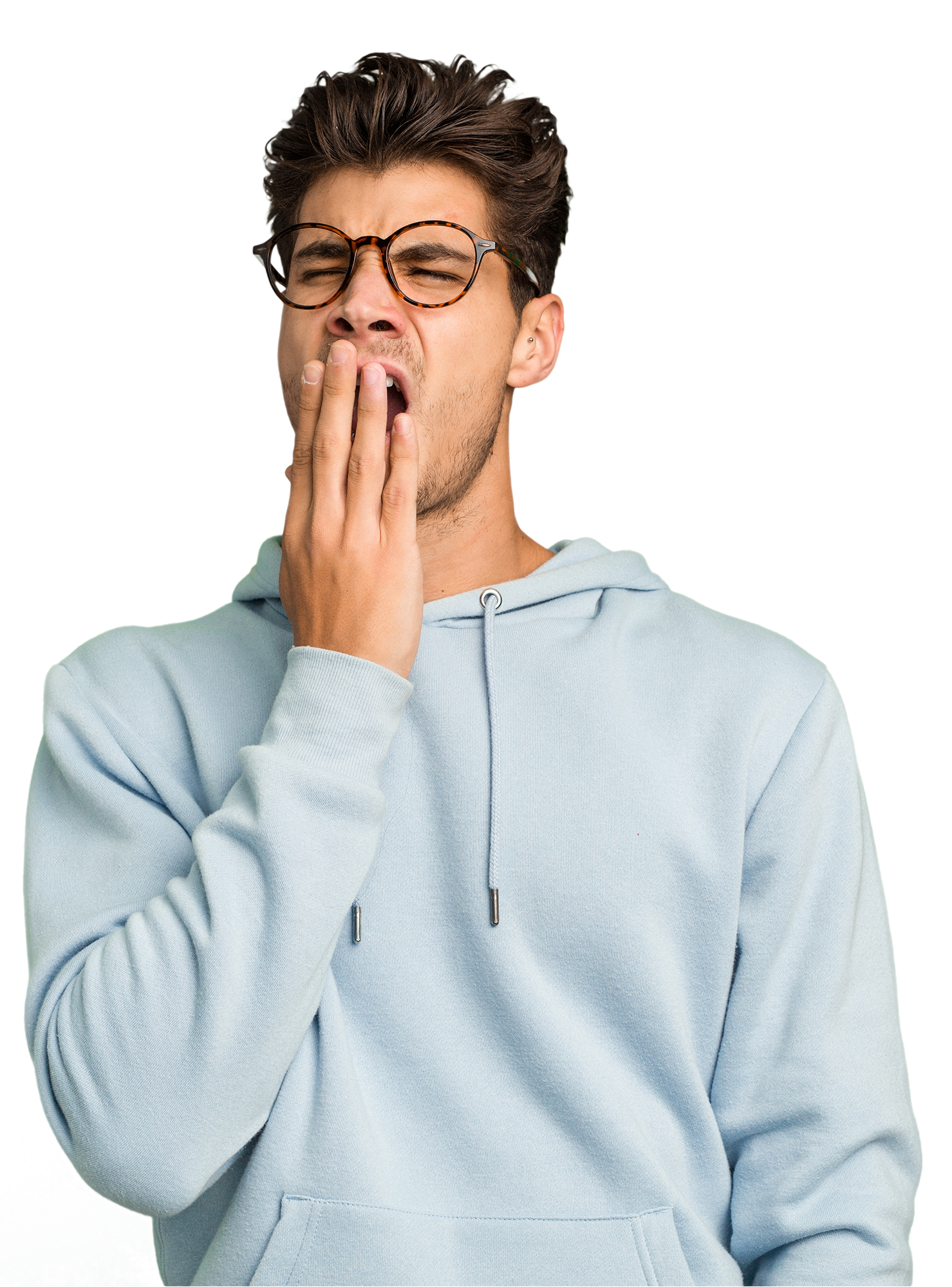 Ein Mann mit hellblauem Hoodie und Brille, der sich die Hand vor den Mund hält und gähnt